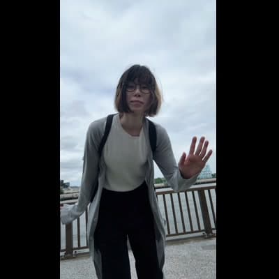 眼鏡をかけた女性が屋外で手をかざす