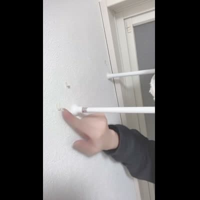 部屋の壁の傷や汚れを見つけ、指で触れたあとゆっくり首を振る